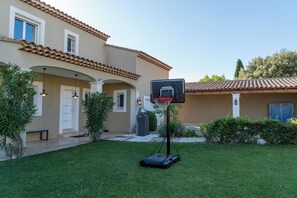 Un edificio residenziale con un campo da basket, una porta e una finestra.