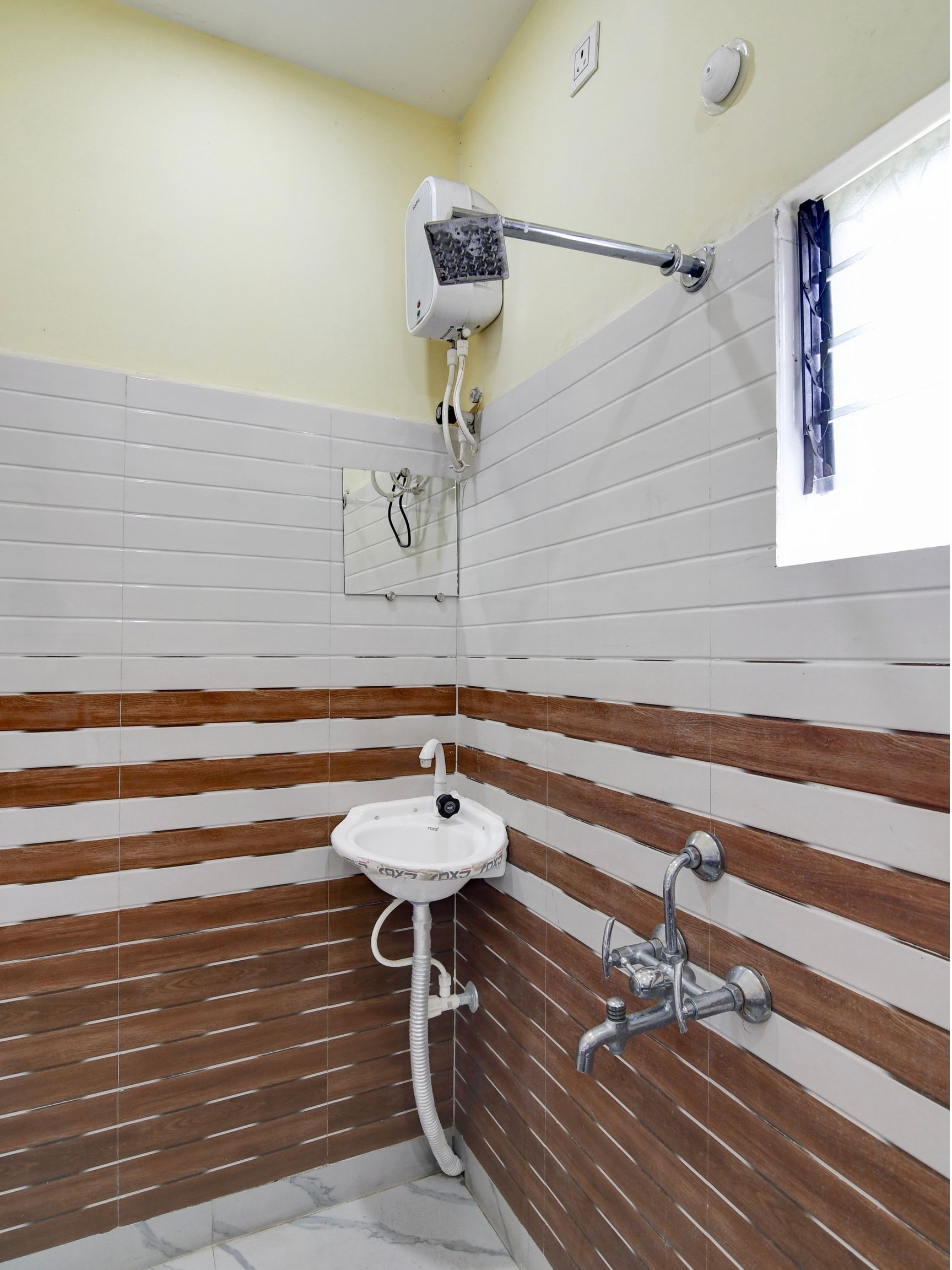 A bathroom with a white sink, a shower, and a towel rack.