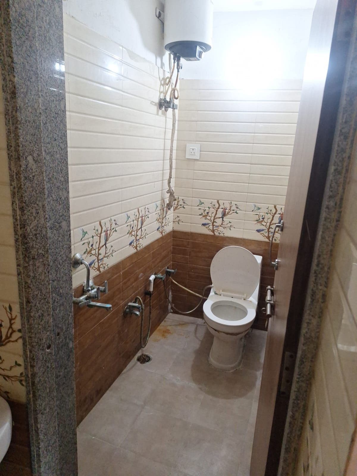 A bathroom with a toilet, a shower, and a wall-mounted water heater.