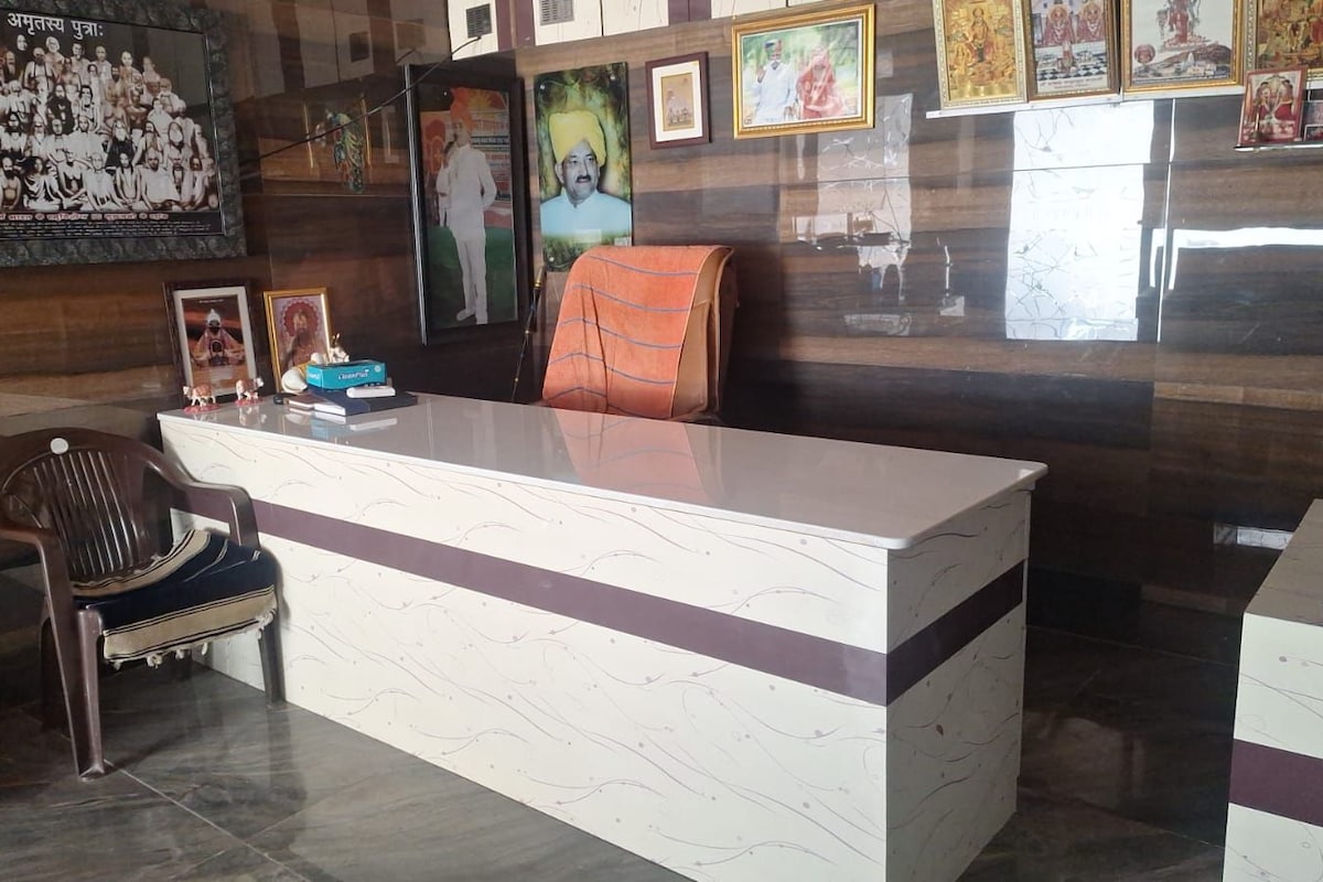 A reception desk with a chair, framed pictures, and a poster on the wall.