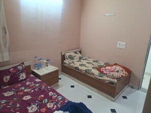 A bedroom with a single bed, a nightstand, and a dresser.