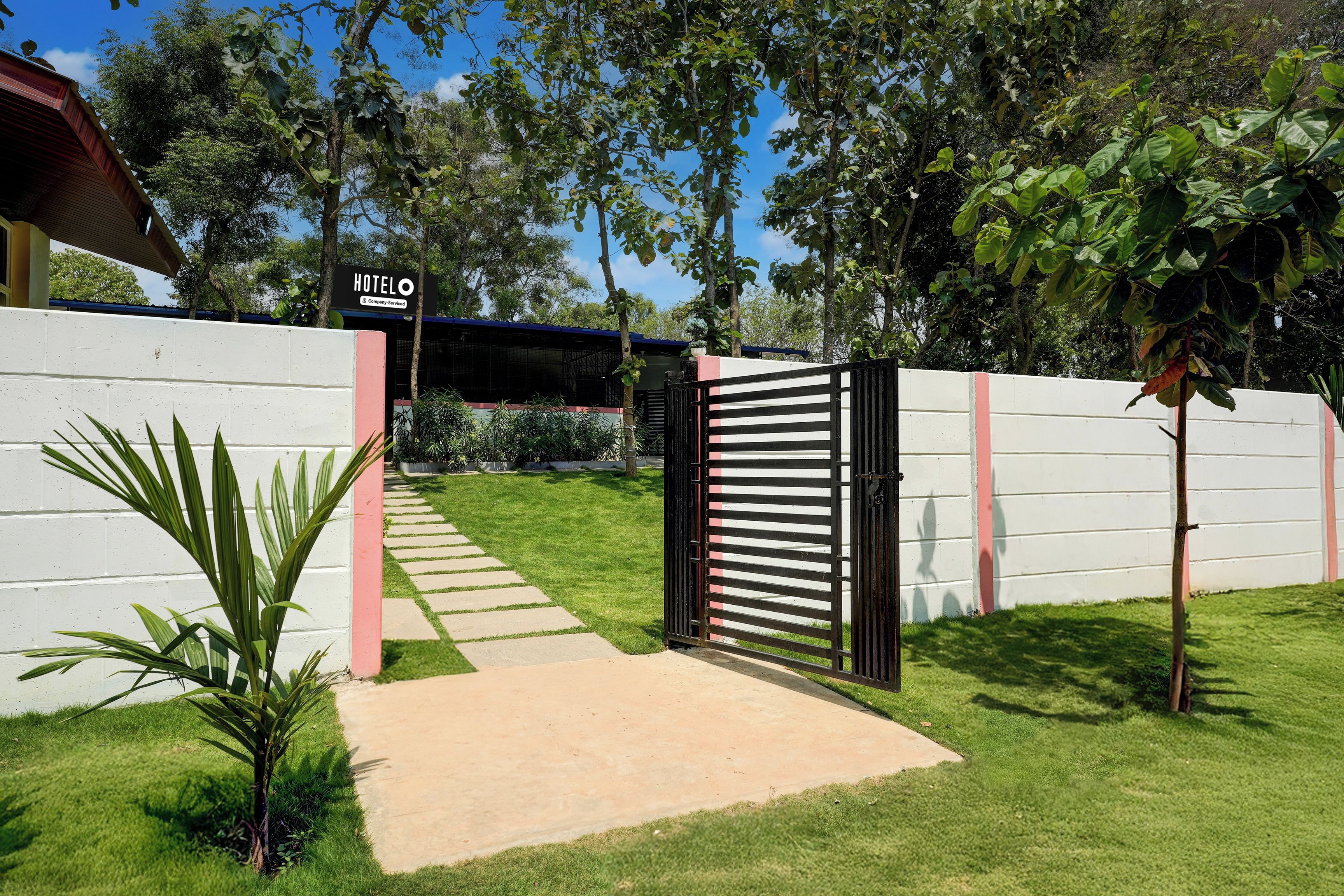A gated entrance to a hotel with a clear pathway leading to the building.