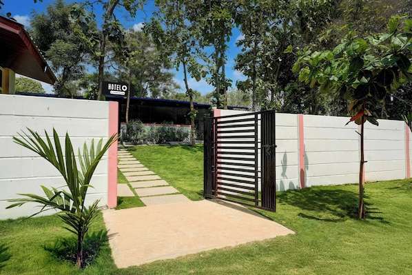A gated entrance to a hotel with a clear pathway leading to the building.