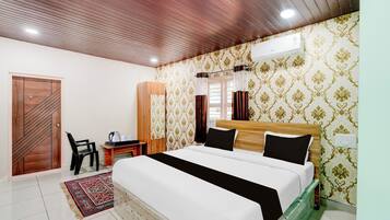 Una habitación de hotel con una cama, un escritorio, una silla y un armario.