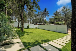 A well-maintained grassy yard with a stone pathway leading to a gated entrance.