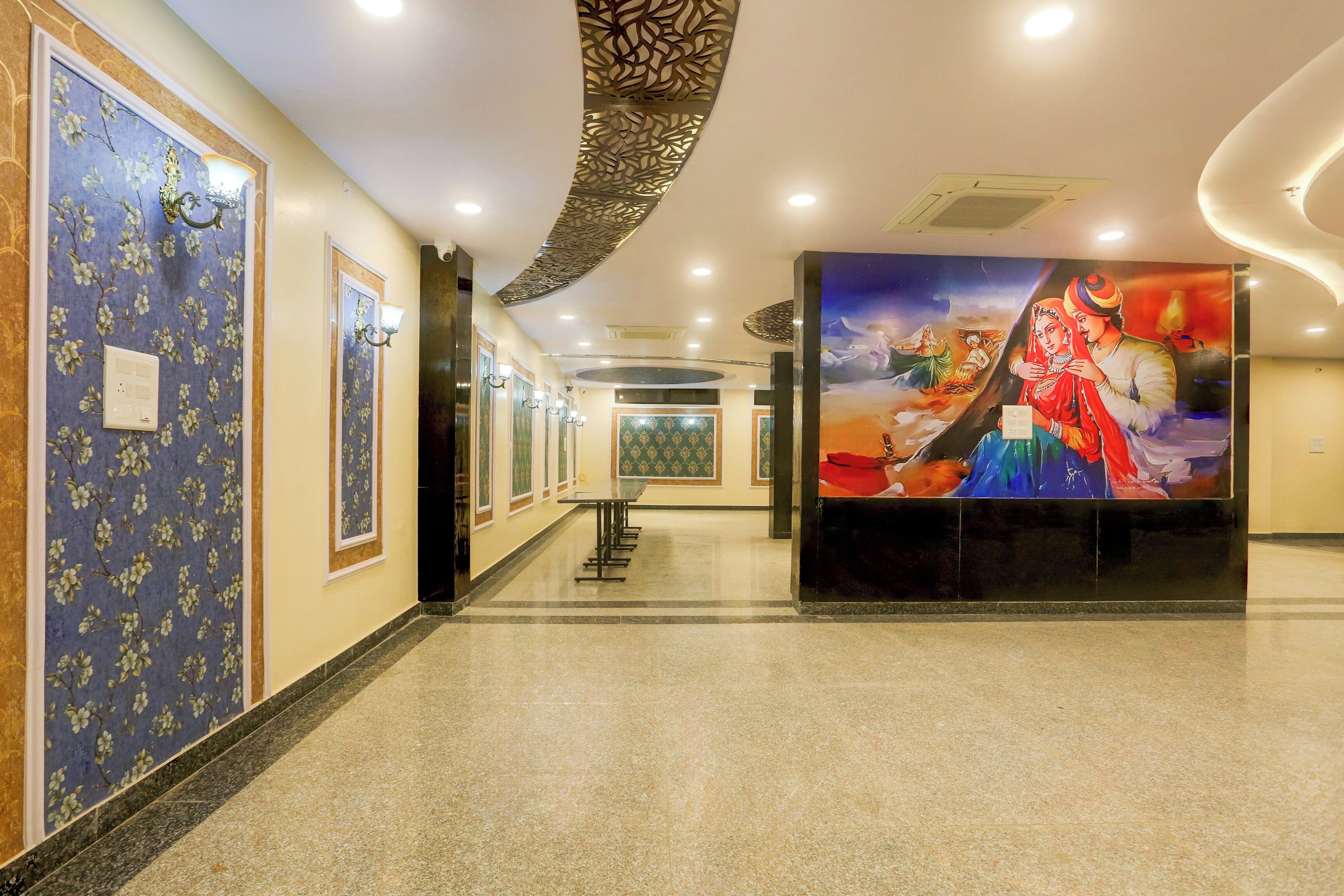Un pasillo de hotel con papel tapiz estampado, un mural grande y una zona de estar.