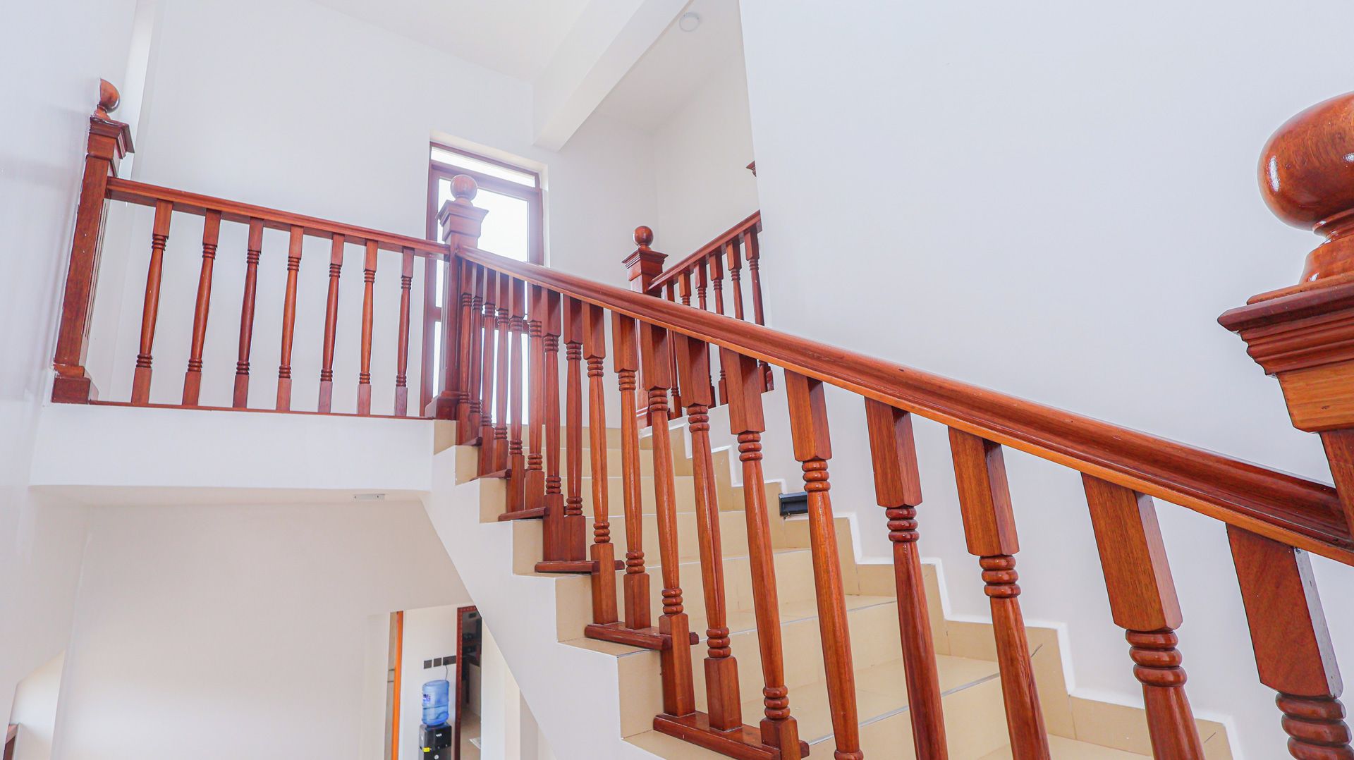 Una escalera de madera con barandilla que lleva a un piso superior.