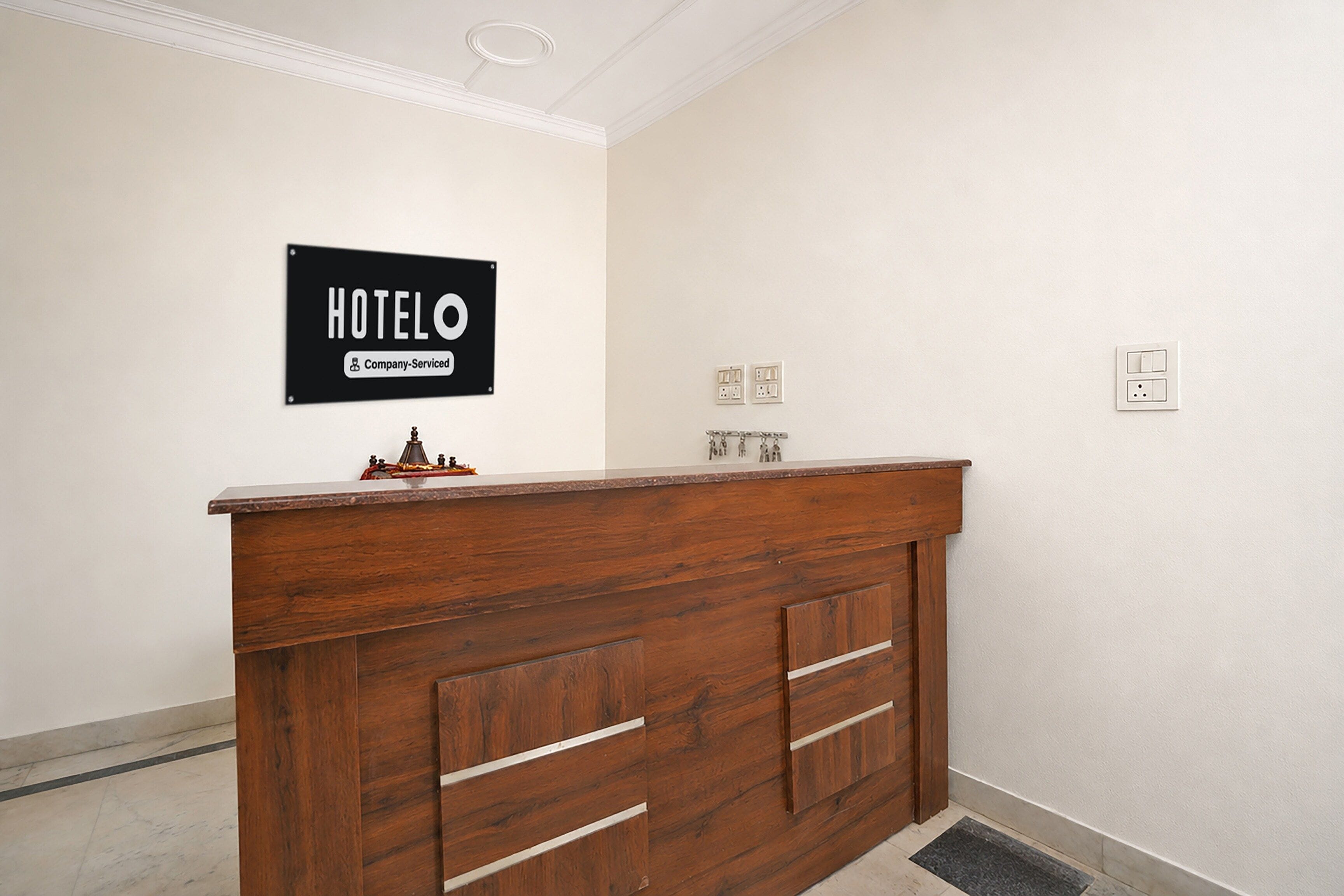 A hotel reception desk with a sign indicating it is company-serviced.