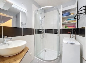 A modern bathroom with a glass-enclosed shower, a sink with a wooden countertop, and a laundry machine. - Studio for 4 ppl near the sea (Agde)