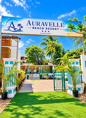 La entrada al Auravelle Beach Resort, con un camino despejado hacia la recepción.