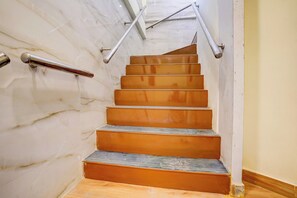 A staircase with metal handrails and a marble wall. - Hotel O Metro Galaxy inn (Mumbai)