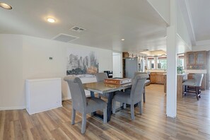 A dining area with a wooden table and striped chairs, a white radiator, and a cityscape painting on the wall. - Near Hiking! Mtn-view Poolside Retreat in Phoenix (Phoenix)