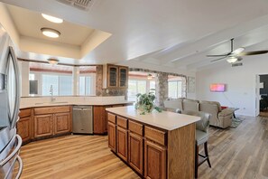 A modern kitchen with wooden cabinets, a built-in dishwasher, and a large island. - Near Hiking! Mtn-view Poolside Retreat in Phoenix (Phoenix)