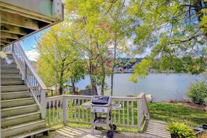 A wooden deck with a grill, a staircase, and a view of a lake. - Lakefront Unit w/ Views, Near Colleges & Hospitals (Worcester)