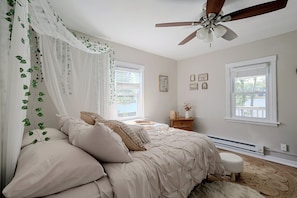A bedroom with a canopy bed, a ceiling fan, and a view of a lake through the windows. - Lakefront Unit w/ Views, Near Colleges & Hospitals (Worcester)
