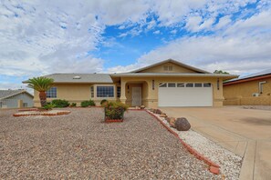 A residential house with a garage, a driveway, and a gravel front yard with landscaping. - Golf, Boat, Swim! Home w/ Lake Havasu & Mtn Views (Lake Havasu City)