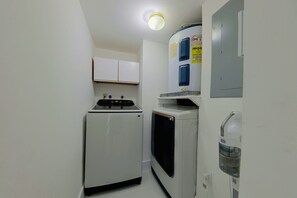 A compact kitchen with a refrigerator, microwave, and a water dispenser. - Relax Poolside, Walk to Ocean! Hillsboro Beach Gem (Hillsboro Beach)