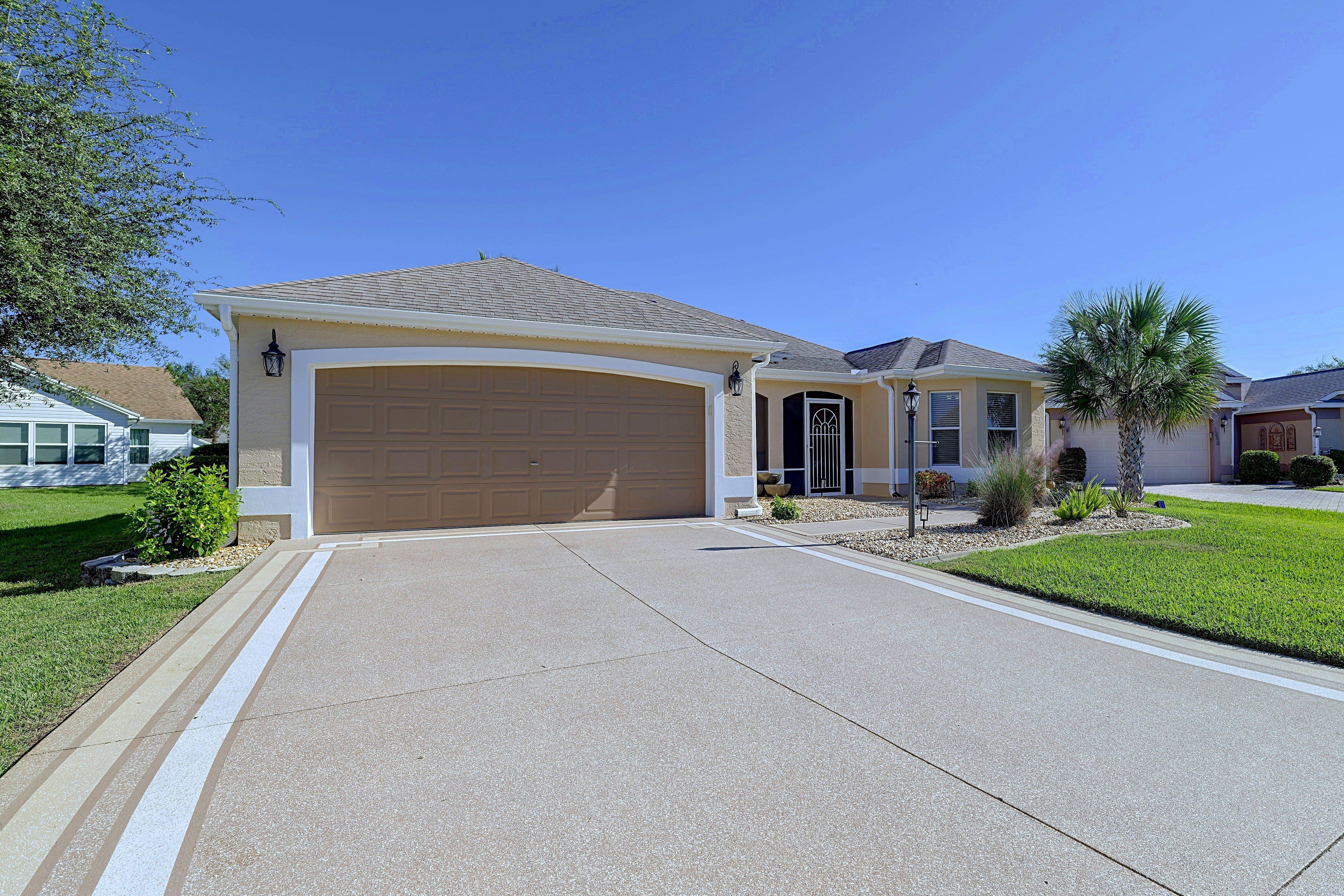 A residential house with a garage, a driveway, and a well-maintained lawn.