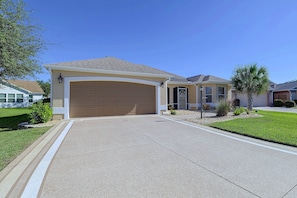 A residential house with a garage, a driveway, and a well-maintained lawn. - 3 Mi to Spanish Springs! Peaceful Retreat (Lady Lake)