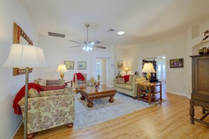 A spacious living room with a ceiling fan, a fireplace, and a large wooden cabinet. - 3 Mi to Spanish Springs! Peaceful Retreat (Lady Lake)