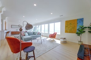 A spacious living room with a sofa, chairs, a coffee table, and a floor lamp. - Your Oceanfront Home Away From Home in Long Beach (Long Beach)