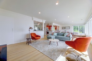 A spacious living room with a large sofa, two armchairs, and a coffee table. - Your Oceanfront Home Away From Home in Long Beach (Long Beach)