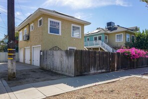 A residential area with two houses, one with a visible garage door and the other with a staircase leading to a porch. - Walk to Pickleball, Parks, Pubs! Cozy Dtwn Apt (Bakersfield)