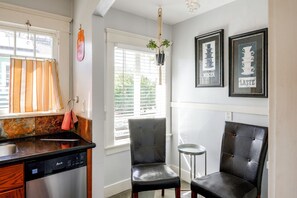 A kitchen with a dishwasher, a chair, and a window with blinds. - Walk to Pickleball, Parks, Pubs! Cozy Dtwn Apt (Bakersfield)
