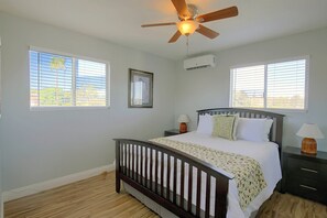 A bedroom with a wooden bed, two bedside tables, a ceiling fan, and two windows with blinds. - Chic Apt < 5 Mi to Sdsu! Private Patio & Views (San Diego)