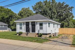 A single-story house with a front porch, a small front yard, and a wooden fence. - 2 Units: Modern Retreat w/ Deck & Workspace (Cincinnati)