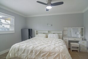 A bedroom with a bed, a vanity with a mirror, and a ceiling fan. - Canal-front Retreat w/ Dock! 5 Mi to Dtwn St Pete (St. Petersburg)