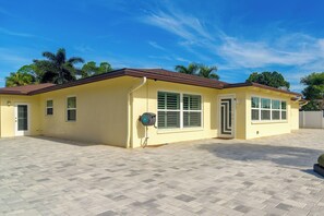 A single-story building with a tiled roof, a garage door, and a paved driveway. - Canal-front Retreat w/ Dock! 5 Mi to Dtwn St Pete (St. Petersburg)