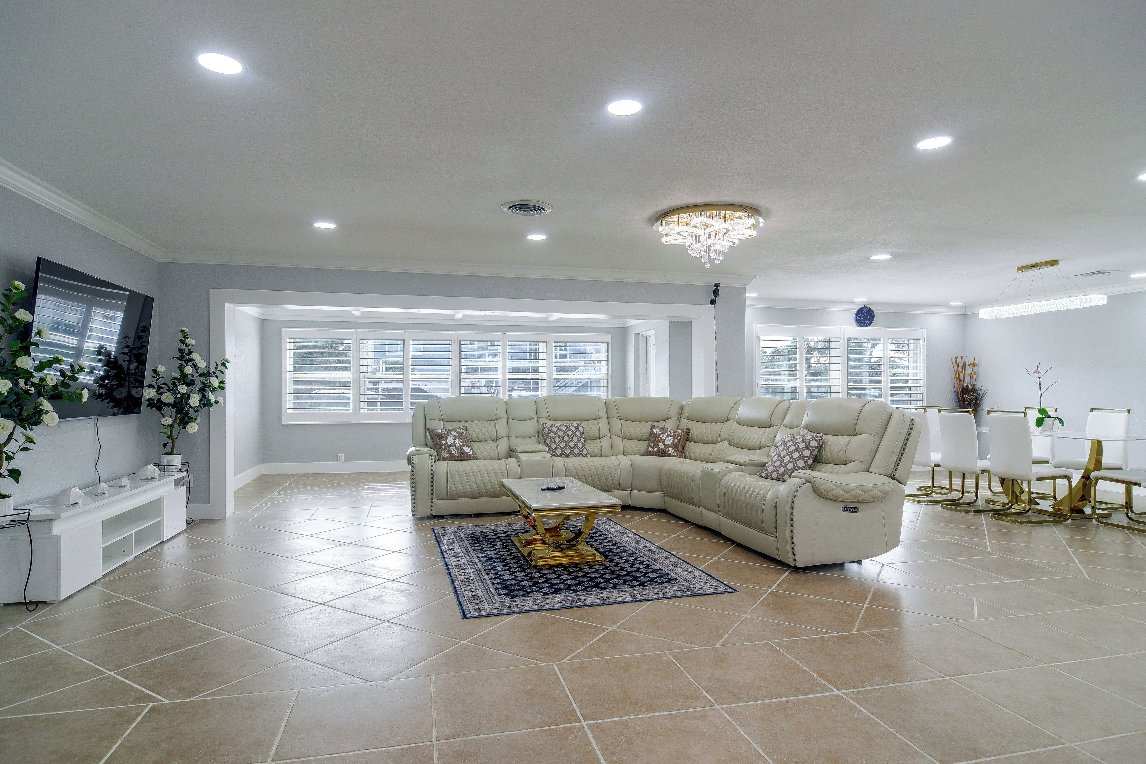 A spacious living room with a sectional sofa, a coffee table, and a chandelier.