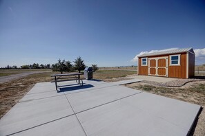 A picnic area with a bench and grill, a small wooden structure, and a clear sky. - 'the Little House on The Prairie' Mtn View! (Peyton)