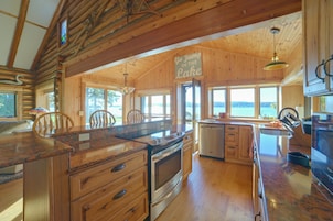 Una cocina amplia con armarios de madera, una isla grande y vistas al lago.