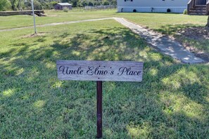 A wooden sign with the inscription 'Uncle Elmo's Place' on a grassy area with a pathway leading to a white building. - Countryside Gem w/ Fire Pit: 14 Mi to Mammoth Cave (Brownsville)