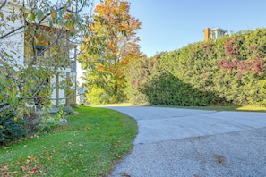 A residential driveway with a gravel path leading to a house with a visible number '8' on the side. - Saint Albans Home: Walk to Main Street! (St. Albans)