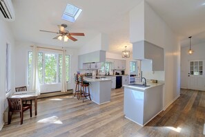 A spacious kitchen with a central island, wooden flooring, and a ceiling fan. - Lake Hartwell Home w/ Quiet Patio & Lake Access (Townville)