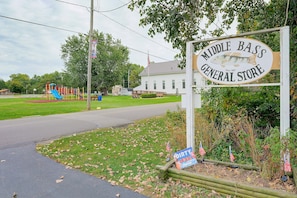 A sign for Middle Bass General Store with a playground in the background. - Water Views + Patio Brews! Middle Bass Island Home (Put-in-Bay)