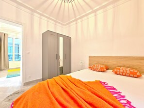 A hotel room with a bed, a wardrobe, a bedside lamp, and a view of the outside. - New Listing (Paris)
