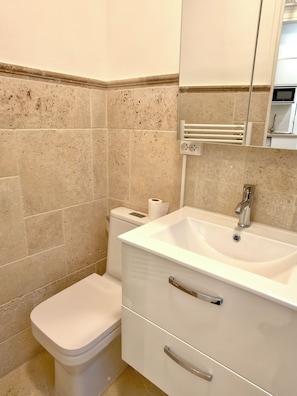 Ein Badezimmer mit Toilette, Waschbecken und Spiegel.