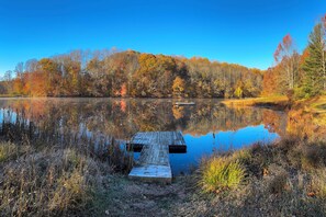 A wooden dock extending into a calm lake surrounded by autumn-colored trees. - Hocking Hills Area Retreat: Relax & Explore! (Rockbridge)