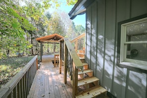 A wooden deck with a wooden staircase leading to a covered area. - Hocking Hills Area Retreat: Relax & Explore! (Rockbridge)