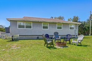 A two-story house with a fenced yard, outdoor seating, and a fire pit. - Riverside Retreat -horse Creel Retreat Arcadia (Fort Ogden)