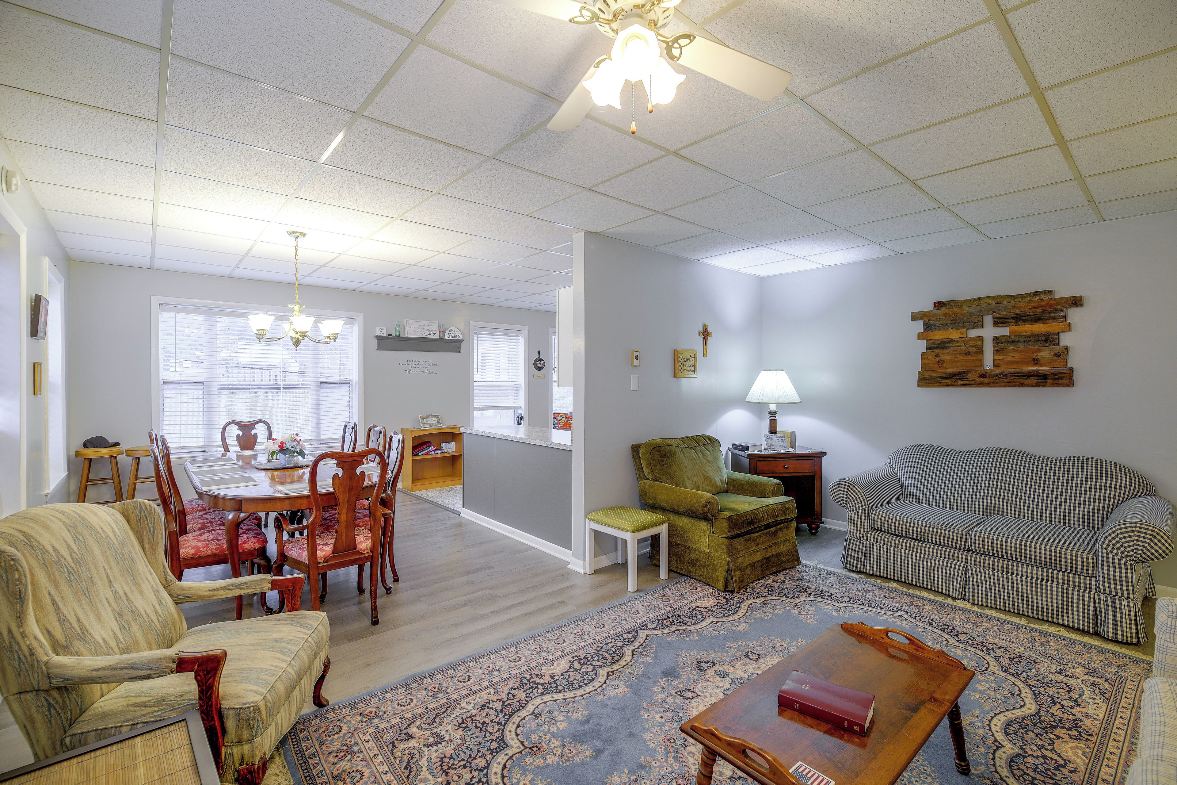 A spacious living room with a dining area, a sofa, a chair, and a coffee table.