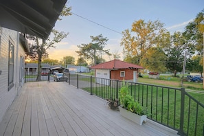 A wooden deck with a metal railing, a small shed, and a red-roofed building in the background. - 1 Mi to Culver-stockton College: Home w/ Yard (Canton)