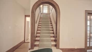 A staircase with wooden railings and a carpeted landing.