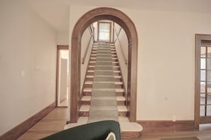 A staircase with wooden railings and a carpeted landing.