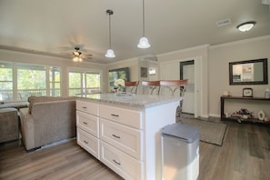 A spacious kitchen with a central island, white cabinetry, and a ceiling fan. - Eucha Home: Grand Lake Views, Boat Ramp Access (Eucha)