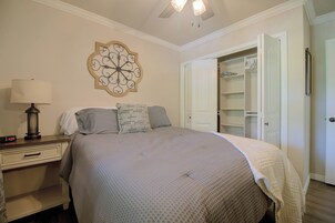 Une chambre à coucher comprenant un lit, une table de chevet, une lampe et un élément décoratif mural.